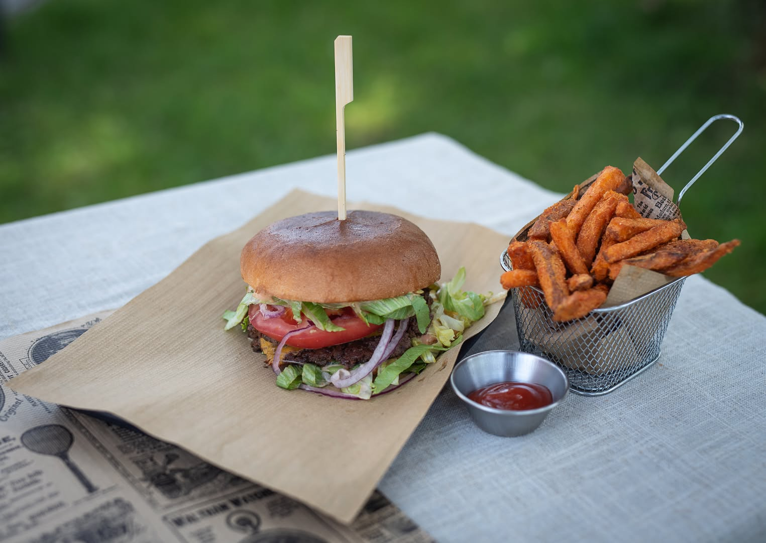 Smash burger z frytkami z batatów na drewnianym stole