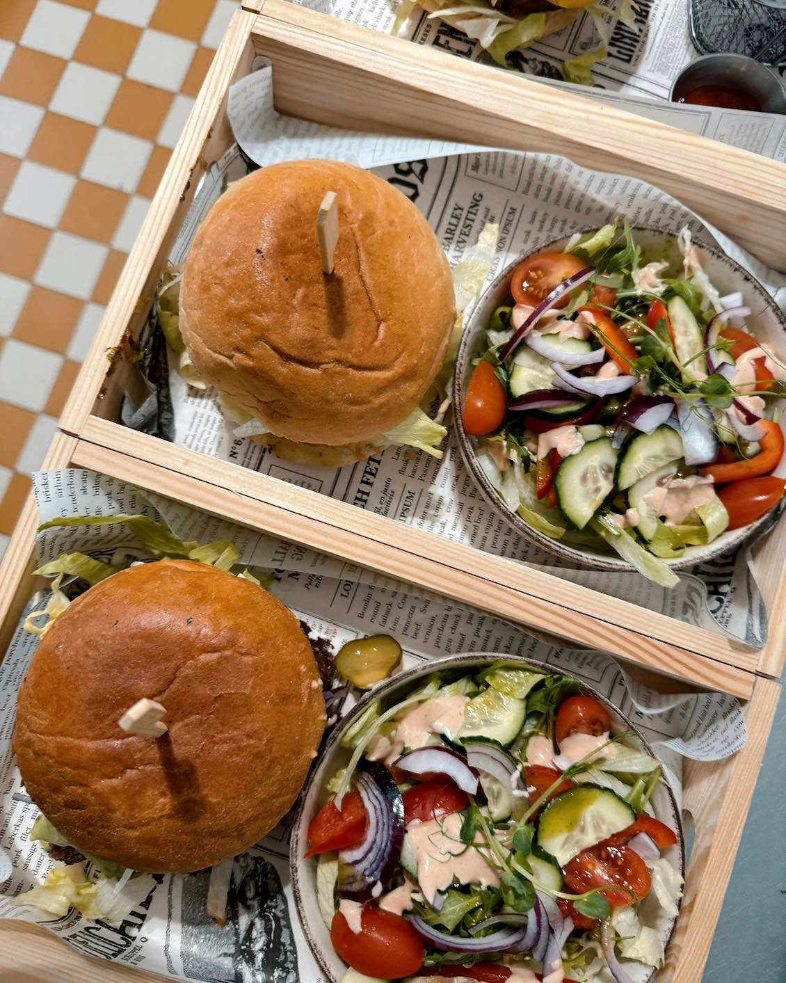 Dwa burgery w drewnianych pudełkach z sałatką